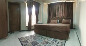 a bedroom with a bed in front of a window at Vaporium 2 bedroom Apartment in Rawalpindi