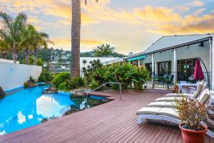 a house with a deck with a swimming pool at Paihia Pacific Resort Hotel in Paihia