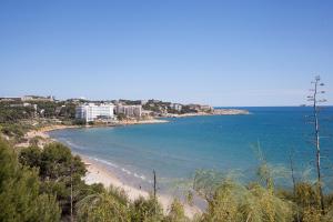 een uitzicht op een strand met gebouwen en de oceaan bij Hotel Best Punta Dorada in Salou