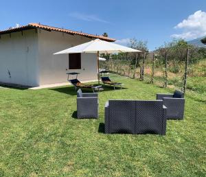 a couple of chairs and an umbrella in a yard at Brass apartment in Castellammare di Stabia