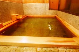 a large pool of water in a room with chairs at K's House Hostels - Hakone Yumoto Onsen in Hakone