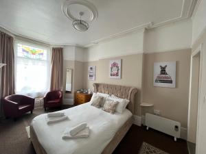 黑潭的住宿－New Derina Hotel，卧室配有一张白色大床和一把椅子