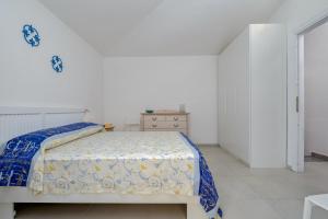 a bedroom with a bed with a blue and white bedspread at Villa Poldina in Budoni