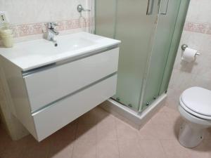uma casa de banho com um lavatório, um chuveiro e um WC. em Hotel Il Parco em Grosseto