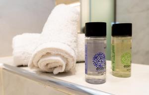 two bottles of soap and towels on a bathroom counter at Nikos Studios in Keri