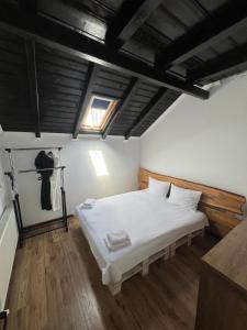 Un dormitorio con una cama blanca y una ventana. en Pensiunea Roxana, en Buzau 27 fotos más