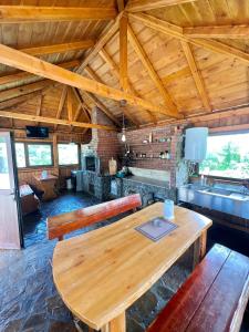 ein Esszimmer mit einem Holztisch und einer Küche in der Unterkunft Pensiunea Roxana in Buzău