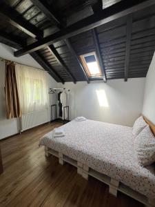 ein Schlafzimmer mit einem Bett in einem Zimmer mit Holzböden in der Unterkunft Pensiunea Roxana in Buzău