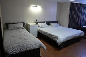 sypialnia z 2 łóżkami i lampką na ścianie w obiekcie Omayah hotel irbid w mieście Irbid