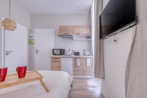 a room with a bed and a table and a kitchen at Short Time Suites Toulon Centre 2 " LE COSY" Check-in auto in Toulon