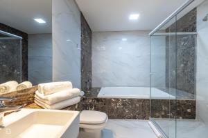 uma casa de banho com um chuveiro, um WC e um lavatório. em Gran Executive Hotel em Uberlândia