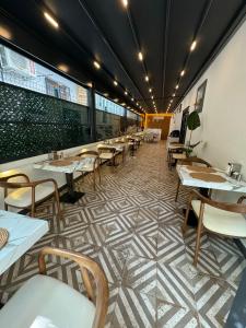 um restaurante com mesas e cadeiras num piso de azulejo em The Rooms Boutique Otel em Kumbağ