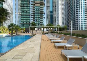 a hotel swimming pool with lounge chairs and buildings at Phenomenal 1BR at Marina Gate 2 in Dubai Marina by Rich Stay in Dubai