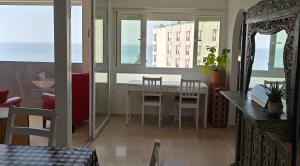 un soggiorno con tavolo, sedie e vista sull'oceano di Marbella Centre Beachfront & Pool a Marbella