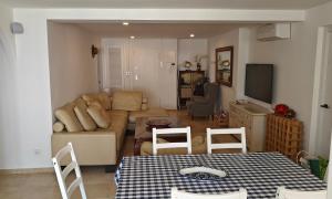 un soggiorno con un divano, un tavolo e delle sedie di Marbella Centre Beachfront & Pool a Marbella