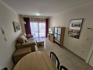 ein Wohnzimmer mit einem Sofa und einem Tisch in der Unterkunft Apartamento El Gemelos in Cala de Finestrat
