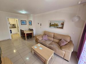 ein Wohnzimmer mit einem Sofa und einem Tisch in der Unterkunft Apartamento El Gemelos in Cala de Finestrat