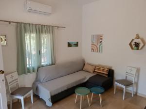a living room with a couch and two chairs at Golden Horizon Retreat, 2 min walk from the sea! in Gournes