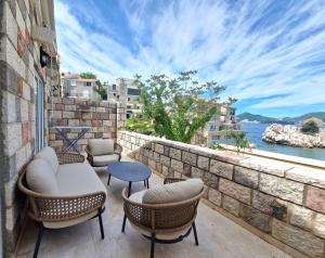 a balcony with chairs and a view of the water at Kazanegra Exclusive Apartments in Sveti Stefan