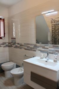 a bathroom with a sink and a toilet and a mirror at Centro storico Bed and Breakfast in Vico del Gargano