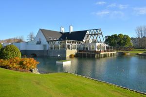 a large house sitting on top of a body of water at Peppers Clearwater Resort in Christchurch