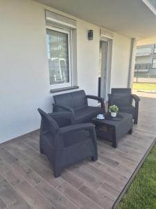 two chairs and a table on a patio at Sonia Pearl Apartament z parkingiem in Sianozety +5 photos