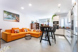 a living room with an orange couch and a kitchen at Apartamento Novasol in Fuengirola