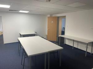 an empty room with tables in an office building at Viola Hostel in Budapest