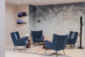a waiting room with blue chairs and a table at Hôtel Best of Both - Divonne-les-Bains in Divonne-les-Bains
