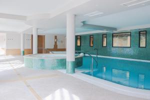 - une piscine dans un bâtiment avec une grande piscine dans l'établissement Best of Both, à Divonne-les-Bains