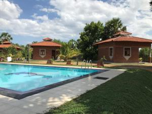 a swimming pool in front of a house at Aki Villa in Pasikuda