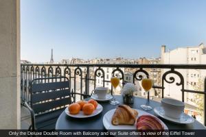 una mesa con comida y bebida en el balcón en Sublim by Sweet Inn en París