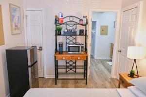 a room with a table with a microwave on a shelf at Cozy Studio - Walk to the Beach! in Jacksonville Beach