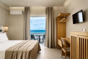 a hotel room with a bed and a view of the ocean at Corali Beach in Tsilivi