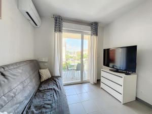 a living room with a couch and a flat screen tv at 3284 - appartement 4 couchages avec piscine in Argelès-sur-Mer
