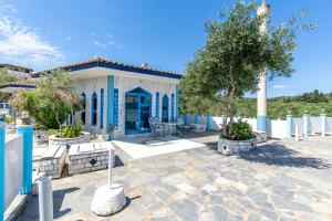 a blue and white building with a tree in front at Paco's Resort Superior Villa 8 in Oziás