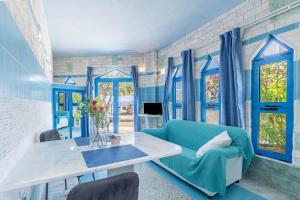 a blue living room with a table and a blue chair at Paco's Resort Superior Villa 8 in Oziás