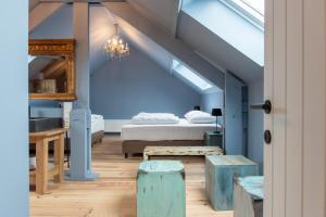 a bedroom with blue walls and a bed and a table at Maisons de vacances Le Vieux Marronnier in Dinant
