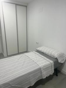 1 dormitorio con 2 camas y ventana en Grande appartement neuf, en Burriana