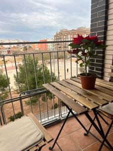 un balcón con un banco de madera y una maceta en Grande appartement neuf, en Burriana