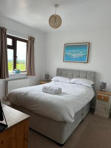 a bedroom with a bed with a stuffed animal on it at Wheal Frances-Beautifully Fitted Bungalow Helston Cornwall in Helston