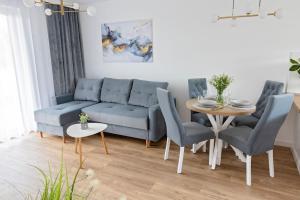 a living room with a blue couch and a table at Apartament Ponidzie in Zbludowice
