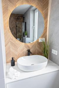 a bathroom with a white sink and a mirror at Apartament Ponidzie in Zbludowice