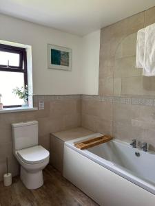 a bathroom with a toilet and a tub and a sink at Wheal Frances-Beautifully Fitted Bungalow Helston Cornwall in Helston