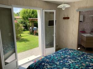 Un dormitorio con una cama y una puerta corrediza de vidrio. en Les Lavatères, en Hiers-Brouage