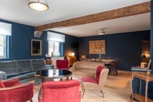 a living room with blue walls and red chairs at Maisons de vacances Le Vieux Marronnier in Dinant