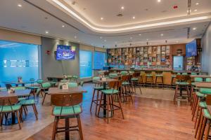 um restaurante com mesas e cadeiras e um bar em Premier Inn Abu Dhabi Airport Business Park em Abu Dhabi