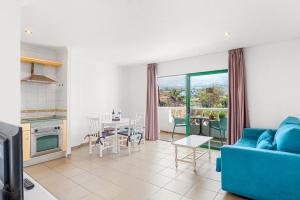 ein Wohnzimmer mit einem blauen Sofa und einem Tisch in der Unterkunft Club Tarahal in Puerto de la Cruz