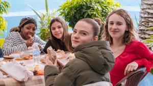 Un groupe de femmes assises à une table et mangeant de la nourriture dans l'établissement Auberge De Jeunesse, à Rabat