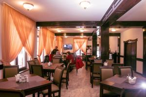 a restaurant with tables and people sitting at them at Hotel Transalpin in Obarsia-Lotrului